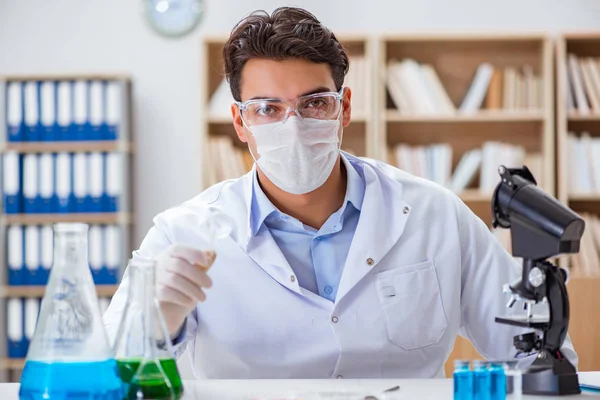 Laboratuvarda virüs aşısı üzerinde çalışan erkek doktor.