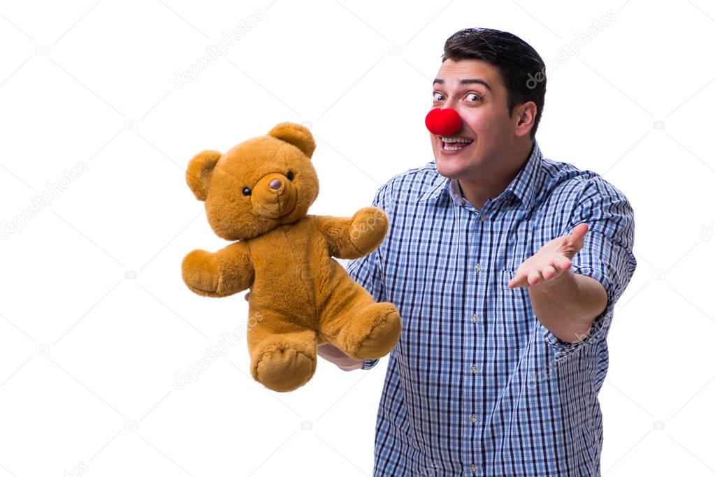 Funny clown man with a soft teddy bear toy isolated on white bac