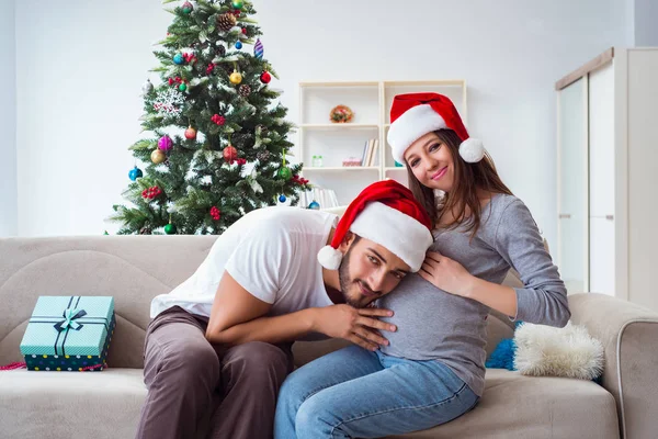 Jeune famille attend bébé célébrant Noël — Photo