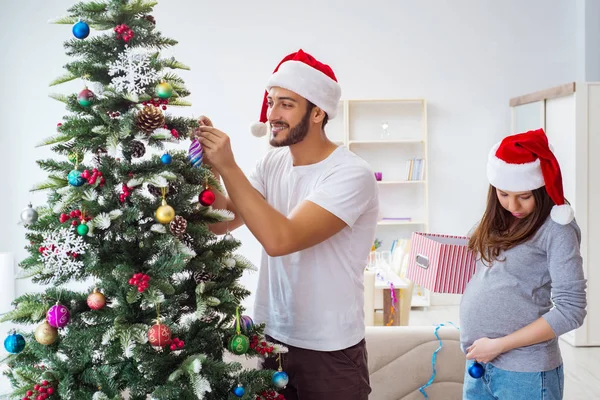 クリスマスを祝う子供の赤ちゃんを期待している若い家族 — ストック写真