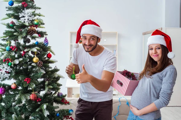 Jeune famille attend bébé célébrant Noël — Photo