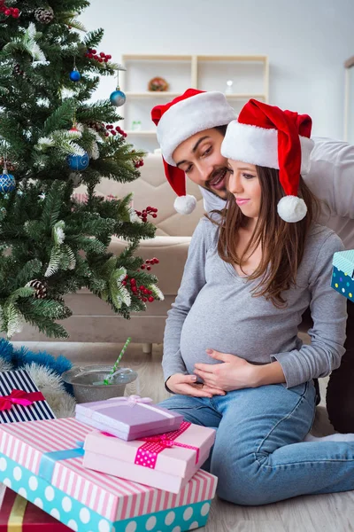 Jong gezin verwacht kind baby vieren kerst — Stockfoto