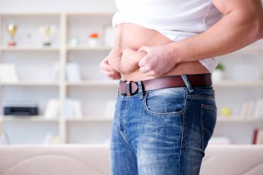 Diyet konseptinde fazladan ağırlık çeken adam.