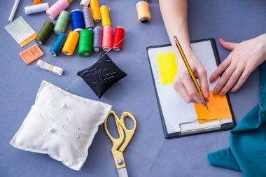 Kadın terzi dikiş dikmek için dikiş dikiyor.