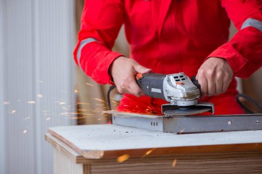 Öğütücü tekerlekle çalışan genç bir tamirci