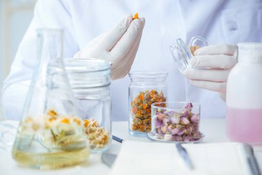 Laboratuvarda parfüm karıştıran bir kimyager.