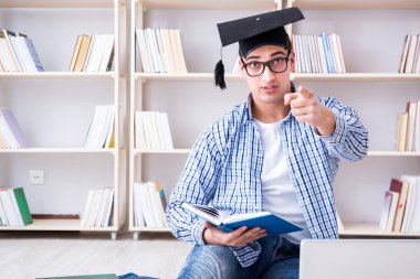 Genç öğrenci kitaplarla çalışıyor.