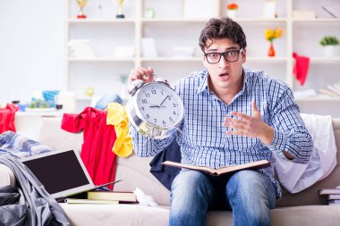 Genç adam dağınık bir odada çalışıyor.