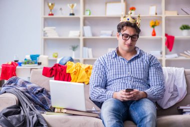 Genç adam dağınık bir odada çalışıyor.