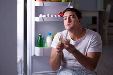 Buzdolabındaki adam gece yemek yiyor.