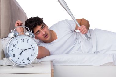 Yatakta uykusuzluk çeken bir adam.