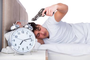 Yatakta uykusuzluk çeken bir adam.