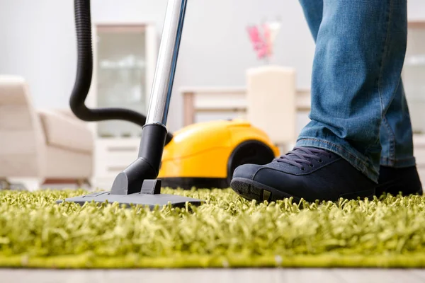 Homem limpando o tapete de chão com um aspirador de pó de perto — Fotografia de Stock