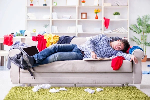 Genç adam dağınık bir odada çalışıyor.