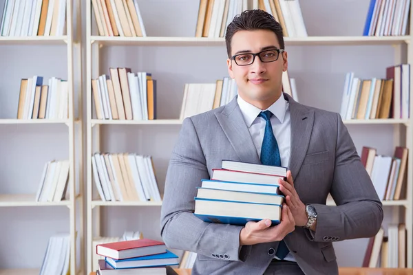 Business law student with pile of books working in library