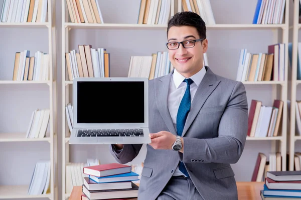 Kütüphanede çalışan boş ekran bilgisayarı olan bir iş adamı.