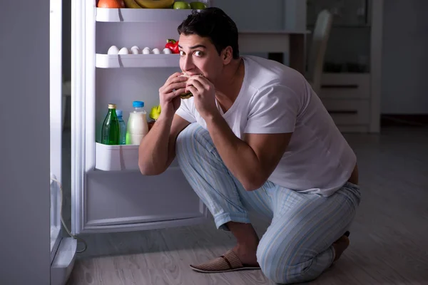 Hombre en el refrigerador comiendo por la noche — Foto de Stock