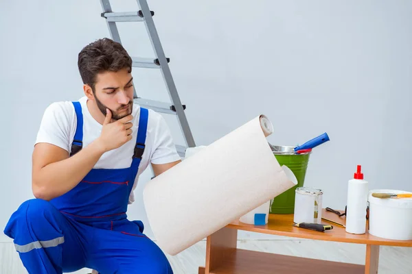 Opravář dělá renovaci opravy v domě s papírovou wallpa — Stock fotografie