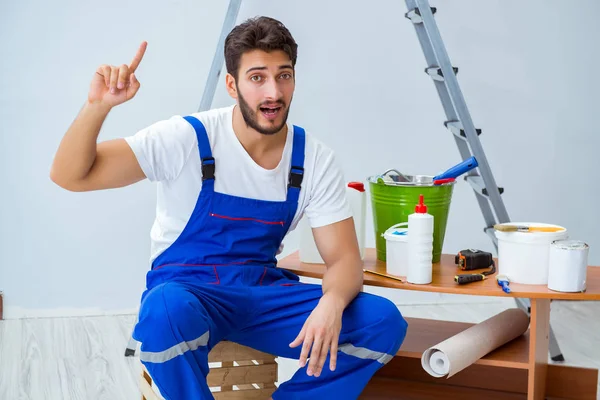 Tamirci, duvar kağıdıyla evde tadilat yapıyor.