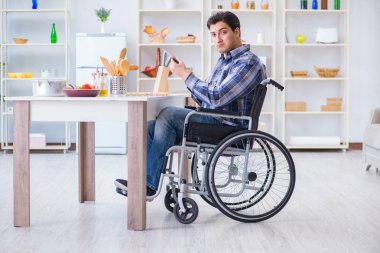 Engelli genç koca mutfakta çalışıyor.