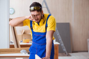 Genç bir marangoz dairesel testereyle odun kesiyor.