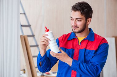 Yooung marangoz boyayla uğraşıyor.