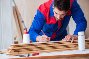 Yooung marangoz boyayla uğraşıyor.