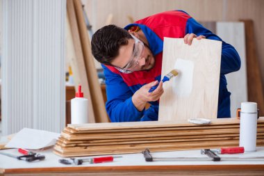 Yooung marangoz boyayla uğraşıyor.