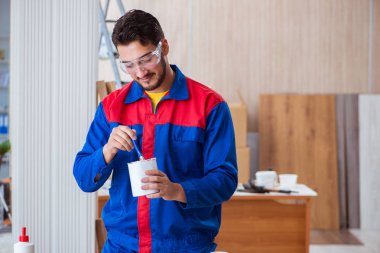 Yooung marangoz boyayla uğraşıyor.