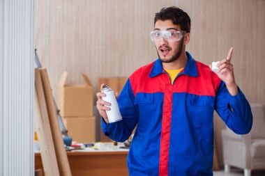 Yooung marangoz boyayla uğraşıyor.