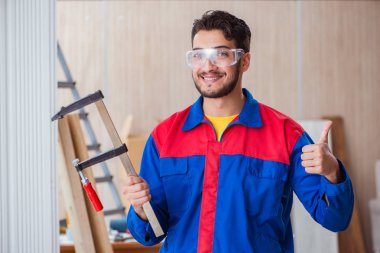 Klemplerle çalışan genç bir tamirci.