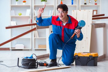 Genç marangoz ahşap kalaslarla çalışıyor.