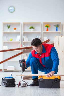 Genç marangoz ahşap kalaslarla çalışıyor.