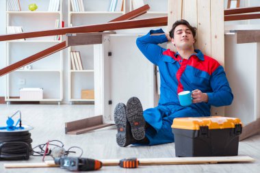 Genç marangoz ahşap kalaslarla çalışmaya ara veriyor.