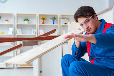 Genç marangoz ahşap kalaslarla çalışıyor.