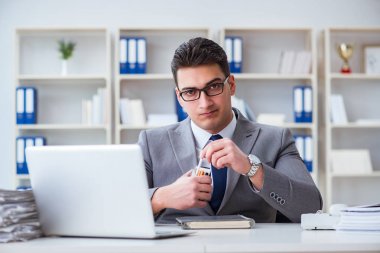 İşadamı ofisinde sigara içiyor.