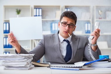 Ofiste sigara içen bir iş adamı elinde boş bir mesaj tutuyor.