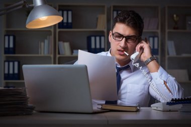 İş adamı telefonda konuşuyor ve ofiste sigara içiyor.