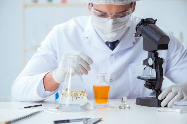 Laboratuvarda parfüm karıştıran bir kimyager.