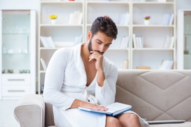 Öğrenci işadamı genç adam bir kitap okuyor.