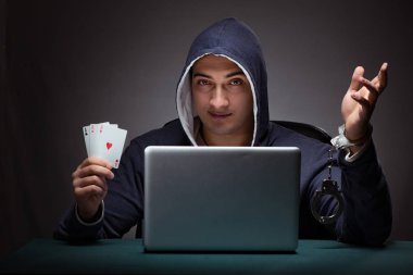 Elleri kelepçeli kapüşonlu genç bir adam Los Angeles 'ın önünde oturuyor.