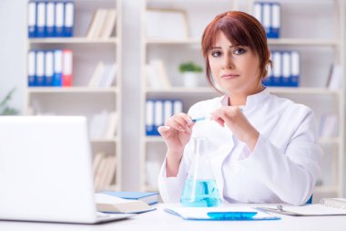 Bir laboratuarda deney yapan kadın bir bilim adamı.