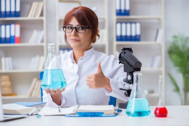 Bir laboratuarda deney yapan kadın bir bilim adamı.