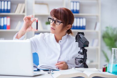 Bir laboratuarda deney yapan kadın bir bilim adamı.