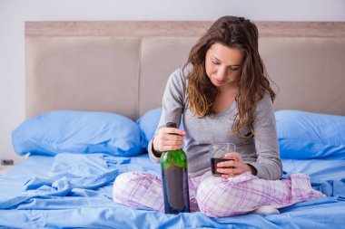 Evde alkol alan genç bir kadın depresyonda.