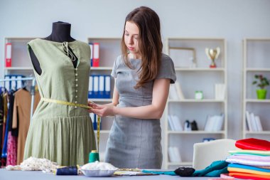 Kadın terzi dikiş dikmek için dikiş dikiyor.