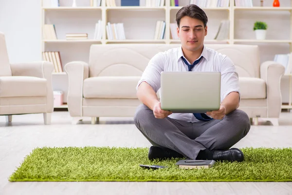 İş adamı ofiste yerde oturuyor.