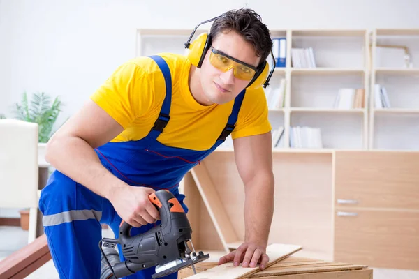 Reparador carpintero cortando aserrar una tabla de madera con un electr —  Fotos de Stock