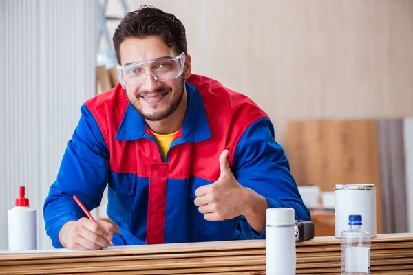 Yooung marangoz boyayla uğraşıyor.