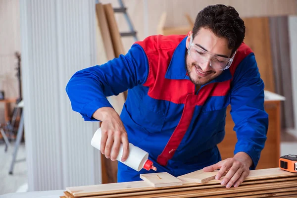 Yooung marangoz boyayla uğraşıyor.